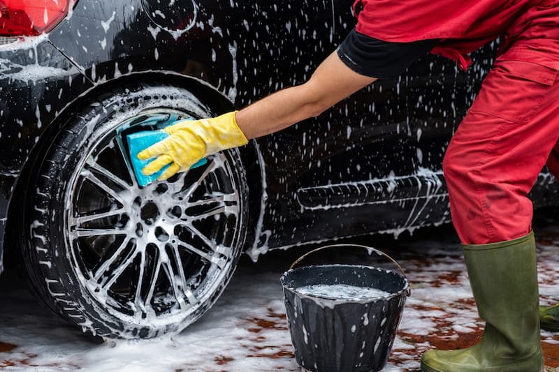 Car wash bay with staff working on a vehicle